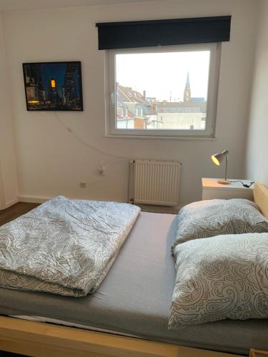 twee bedden in een kamer met een raam bij Easy travel - apartment in Krefeld Zentrum in Krefeld