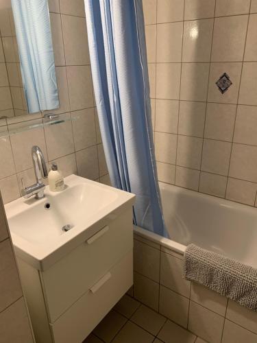 uma casa de banho com um lavatório, um chuveiro e uma banheira em Easy travel - apartment in Krefeld Zentrum em Krefeld