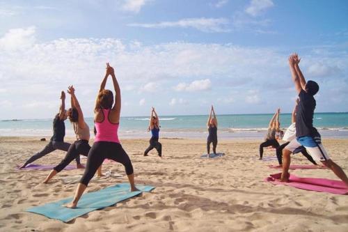 a group of people doing yoga on the beach at Most Requested 16 Br Oceanfront Home in Holden Beach in Holden Beach