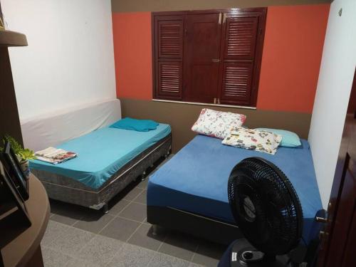 2 camas individuales en una habitación con paredes rojas en Sítio RoThaS, en Beberibe