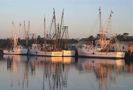 three boats are docked in the water at Most Requested 16 Br Oceanfront Home in Holden Beach in Holden Beach