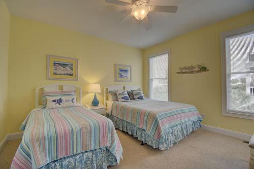 a bedroom with two beds and a ceiling fan at Most Requested 16 Br Oceanfront Home in Holden Beach in Holden Beach