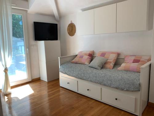 Cette chambre comprend un lit avec deux oreillers et une télévision. dans l'établissement Jolie maison familiale proche lac et océan, à Biarritz