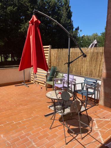 un grupo de sillas y una sombrilla roja en un patio en Da Giulia, en Reggio Calabria