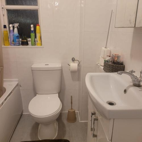 a white bathroom with a toilet and a sink at Exquisite 3-Bed Royal Pearl Home in Greater London in Thamesmead