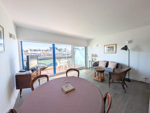 ein Wohnzimmer mit einem Tisch und einem Sofa in der Unterkunft Superbe appartement et vue - 4 pers - Parking in La Baule