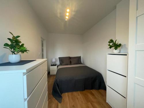 a bedroom with a bed and two potted plants at M3 Pruszków in Pruszków
