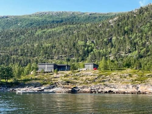 a couple of houses on a hill next to the water at Efjord - magic nature in Ballangen