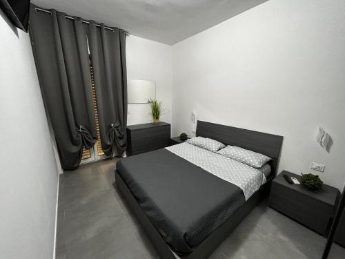 een slaapkamer met een zwart bed en zwarte gordijnen bij Le magnolie in San Salvo