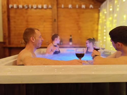un gruppo di persone in una vasca da bagno con bicchieri di vino di Pensiunea Irina Maramureș a Deseşti