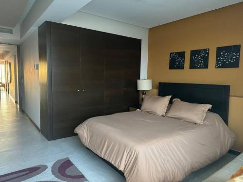 a bedroom with a large bed with a black headboard at Departamento de Lujo Vista al mar Piso 15 in Mazatlán
