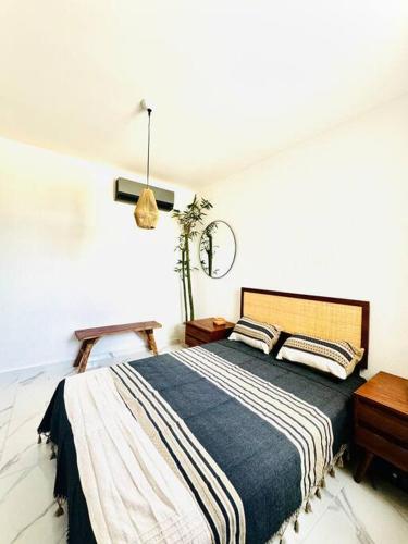 a bedroom with a bed with a blue and white blanket at Departamento eco-chic a 10 min del centro in Tulum