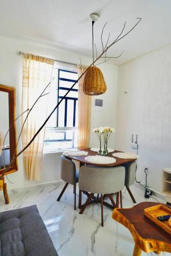 a dining room with a table and chairs and a window at Departamento eco-chic a 10 min del centro in Tulum