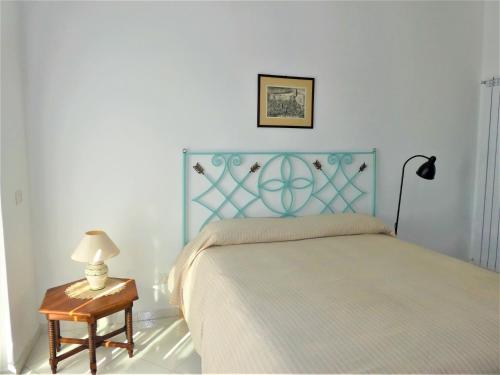 ソレントにあるSoggiornisorrentoのベッドルーム1室(青いヘッドボードとテーブル付きのベッド1台付)