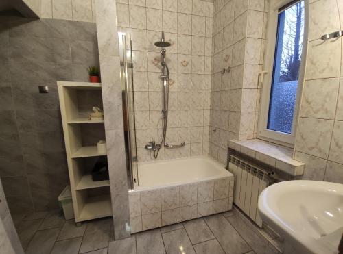 a bathroom with a shower and a tub and a sink at Villa For You in Oświęcim