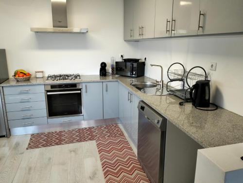 eine Küche mit weißen Schränken und einer Arbeitsplatte in der Unterkunft CASA NOVA MONTALEGRE in Montalegre