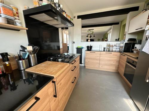 une grande cuisine avec des armoires en bois et une cuisinière dans l'établissement Maison du Bonheur, à Montigny-lès-Metz