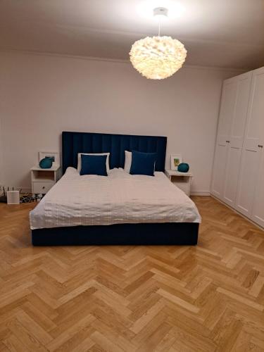 a bedroom with a large bed and a chandelier at Lägenhet på Rosenlund in Jönköping