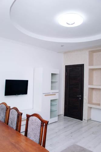 a dining room with a table and a flat screen tv at Ехо Тростяну in Slavske