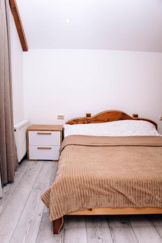 a bedroom with a bed and a wooden floor at Ехо Тростяну in Slavske