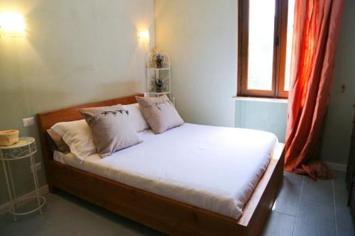 a bed with white sheets and pillows in a room at Borgo Tiedoli in Borgo Val di Taro