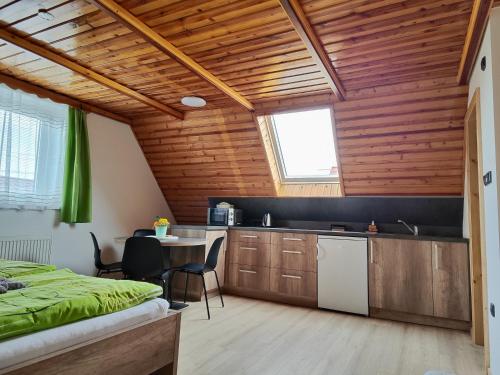 a room with a kitchen with wooden ceilings and a bed at Penzion Burda in Sepekov