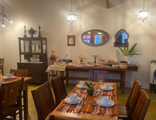 a dining room with a table and chairs and a mirror at Pousada Mãe Natureza in Pirenópolis