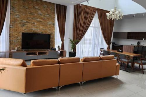 a living room with a couch and a television at Zinnia Residence in Tanah Rata