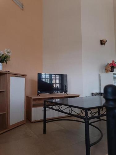 ein Wohnzimmer mit einem Tisch und einem TV in der Unterkunft Résidence cœur de Marie in Abomey-Calavi