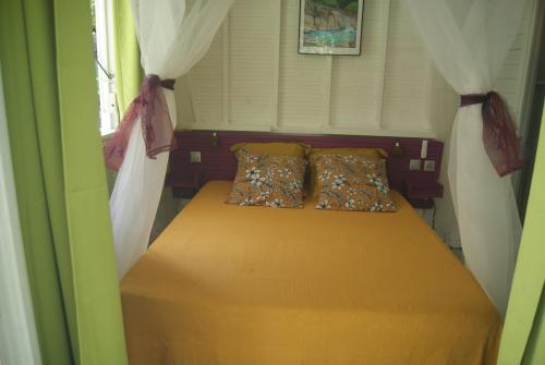 - un lit avec deux oreillers dans une petite chambre dans l'établissement Kaz à Skanky, au Gosier