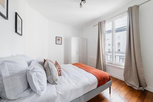 ein weißes Schlafzimmer mit einem Bett und einem großen Fenster in der Unterkunft Spacieux 2 Chambres Appart Boulogne-Quai in Boulogne-Billancourt