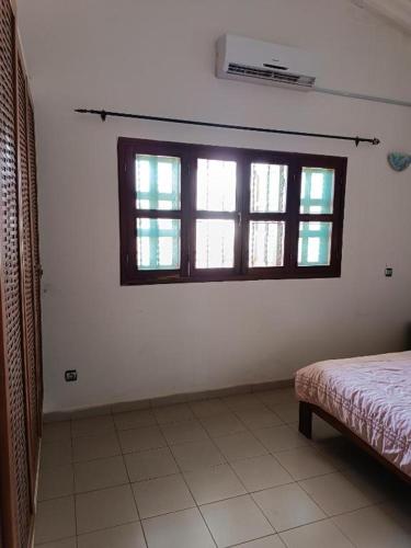 Schlafzimmer mit einem Bett und einem Fenster in der Unterkunft Résidence cœur de Marie in Abomey-Calavi
