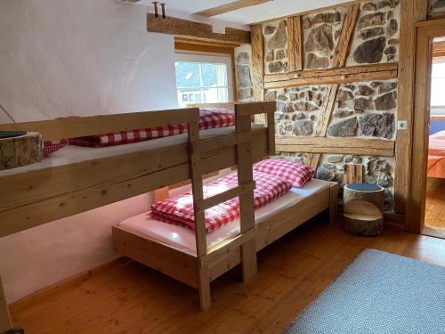 フィリンゲン・シュヴェニンゲンにあるSchwarzwald - Ferienhaus in Tannheimの石造りの壁の客室で、二段ベッド2組が備わります。
