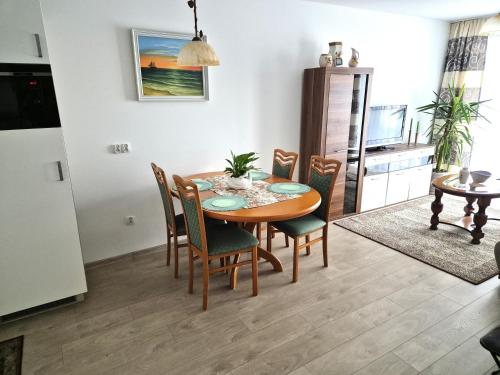 a kitchen and dining room with a table and chairs at Apartament Bałtycka 6B in Kołobrzeg