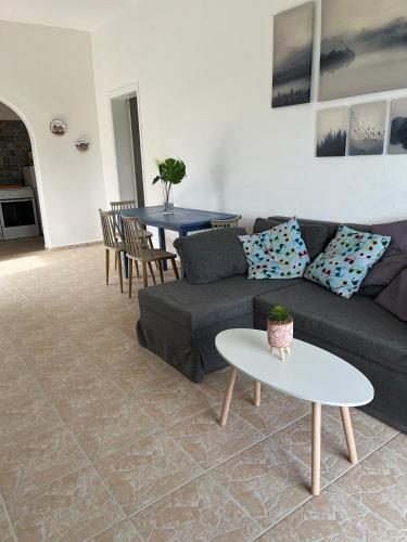 a living room with a couch and a table at Ariadni's home - Einfamilienhaus mit Meerblick in Nea Stira