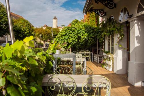 a patio with tables and chairs and a building at Auberge d'Ajoie in Porrentruy