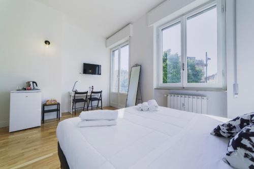 ein weißes Schlafzimmer mit einem großen weißen Bett und Fenstern in der Unterkunft Lavagnini My Place B&B in Florenz
