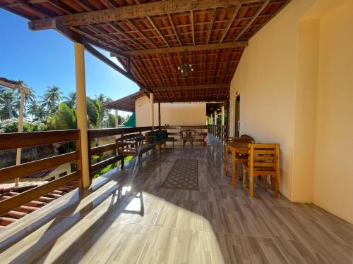 a dining room with tables and chairs on a balcony at Pousada Lua Cheia in Japaratinga