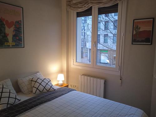 a bedroom with a bed and two windows at Apartamento Guggenheim cèntrico y confortable in Bilbao