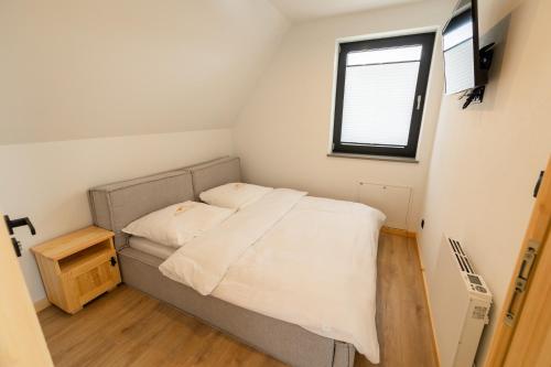 a small bed in a small room with a window at Hreśkowa Osada - Domki w Górach in Szaflary