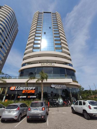 un gran edificio con coches estacionados frente a él en Torres Brickell. en Tigre