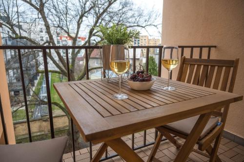 a table with two glasses of wine and a bowl of fruit at Apartmán u Výstaviště in Olomouc