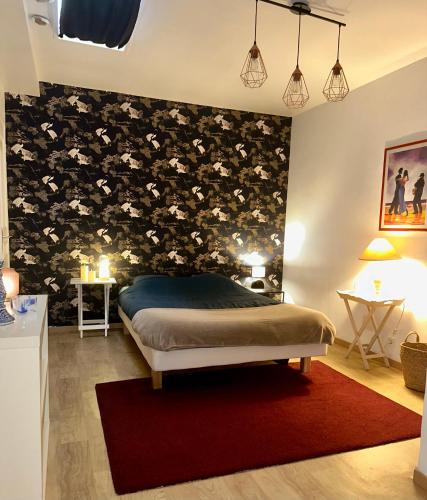 une chambre avec un lit avec un mur d'accent floral dans l'établissement Appartement au cœur du vieux Rouen, à Rouen