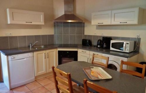 - une cuisine avec une table et un four micro-ondes dans l'établissement La Maison d'Aimée, à Vielle-Aure