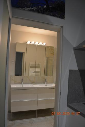 une salle de bain avec deux lavabos et un grand miroir dans l'établissement LA BAMBOUSERAIE, à Saint-Rémy-de-Provence