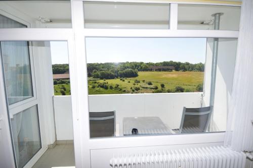 ein Fenster mit Blick auf ein grünes Feld in der Unterkunft Ferienpark Hs N Etage 8 Whg 2 in Heiligenhafen