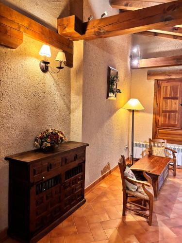 a dining room with a wooden table and a table and chairs at Casa Rural Abuelo Regino in Segovia