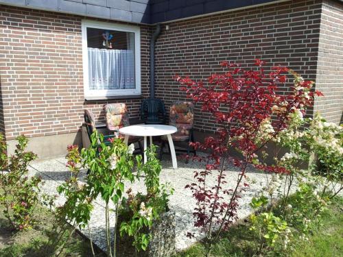 eine Terrasse mit einem Tisch und Stühlen vor einem Gebäude in der Unterkunft Sandkamp 7 Wohnung 3 in Heiligenhafen