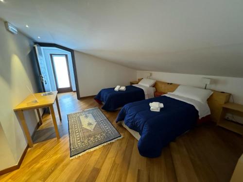 a room with two beds and a table and a desk at Kalos Relais in Catanzaro