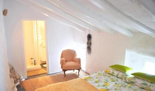 a bedroom with a chair and a bed in it at Casa Rural Recovecos in Algodonales